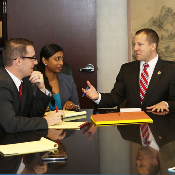 Ethan Irwin, attorney, talking to colleagues in a law office setting.