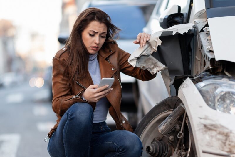Lady calling lawyer at scene of car accident.